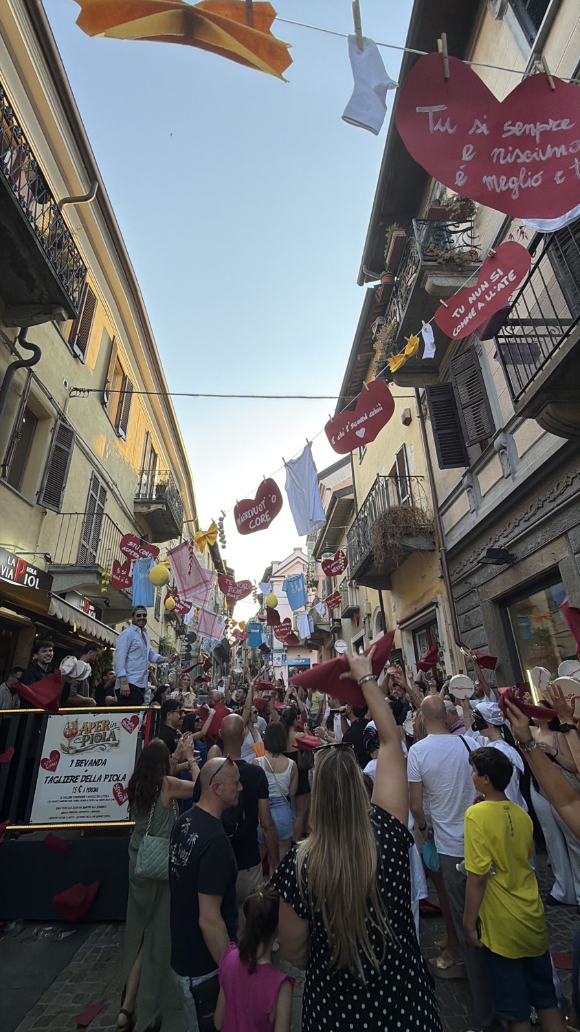 Mani alzate e tamburelli in mezzo alla via addobbata